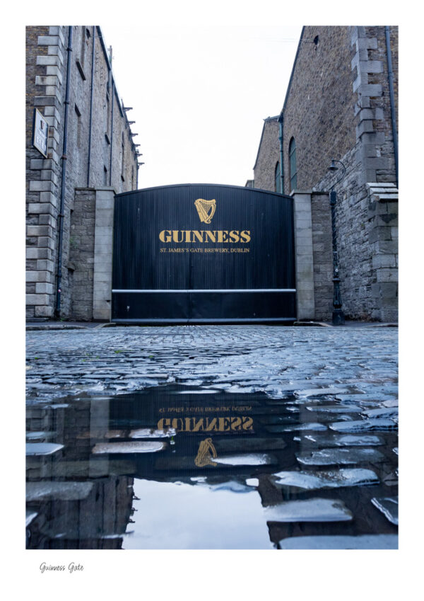 The iconic Guinness Gate, with a pool of water in front and the reflection of Guinness in the water
